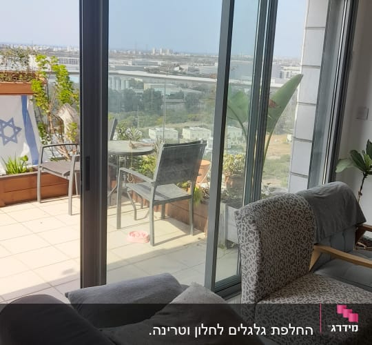 תריסים זכוכית גדולים במרפסת עם נוף עירוני